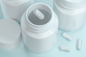 Minimalist white bottles with glossy capsules on a soft blue background – clean and modern concept for white label nutritional supplements.