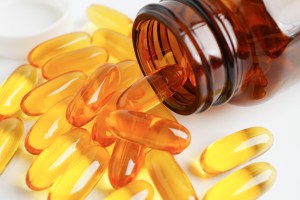 The image depicts a close-up view of food supplements, specifically omega-3 or fish oil soft gel capsules, which are commonly produced by food supplement manufacturers, supplement manufacturers, and dietary supplement manufacturers. These translucent greenish-yellow soft gels emphasize the high-quality formulation and purity of the product, often linked to benefits like heart health, brain function, and overall wellness.