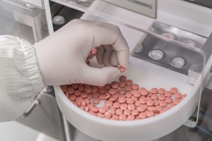 Macro Shot of colour Pills and Capsules During Production and Packing Process on Modern Pharmaceutical Factory. Tablet and Capsule Manufacturing Process. Close-up Shot of Medical Drug Production Line. Supplement Manufacturing