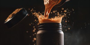 Dynamic close-up of private label protein powder being poured into a black shaker bottle, creating an energetic splash effect against a dark background