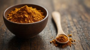 Private label turmeric powder elegantly displayed in wooden bowls and spoons on a dark wooden board, highlighting premium quality organic turmeric for health and culinary application