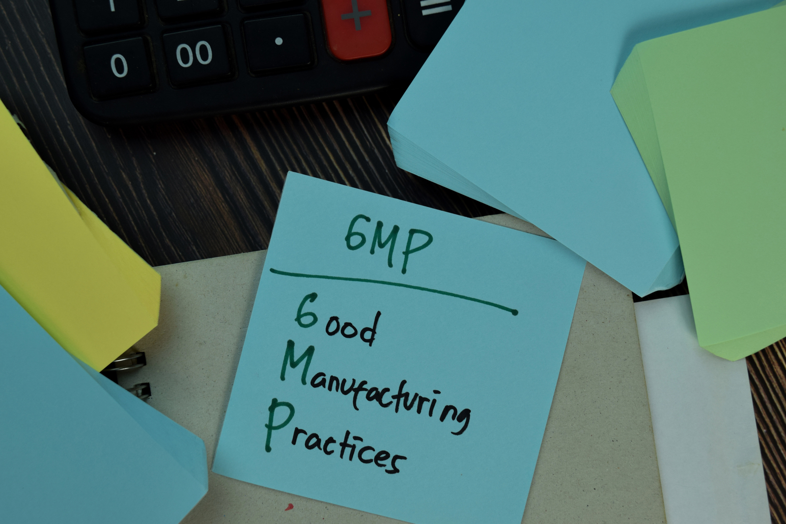 GMP Certification for supplement manufacturers Practices write on sticky notes isolated on Wooden Table.