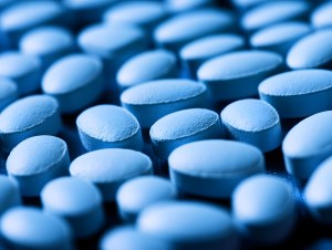 Macro shot of blue coated tablets produced by a pharmaceutical tablet manufacturer, representing quality healthcare supplements and precision tablet formulation