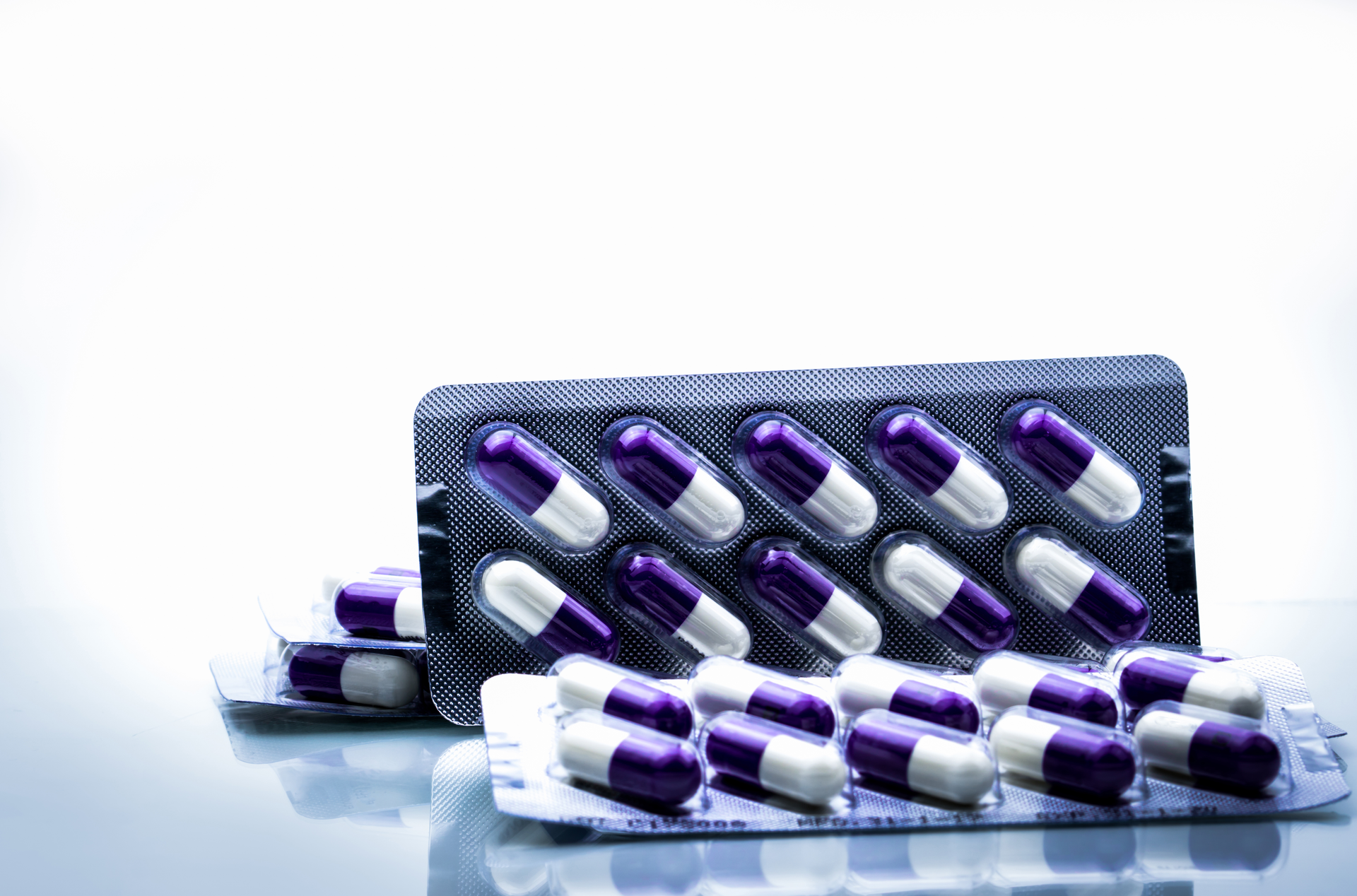 Blister packs of purple and white capsules produced by a reliable capsule contract manufacturer for pharmaceutical and nutraceutical products.