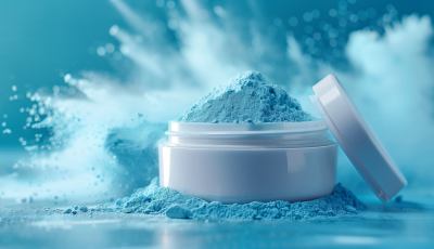 A vibrant blue powder product in a sleek white jar with an open lid, surrounded by a dynamic powder splash effect, representing high-quality custom powder formulation.